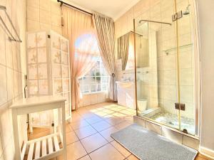 uma casa de banho com um chuveiro e um lavatório. em Barberton BnB em Barberton