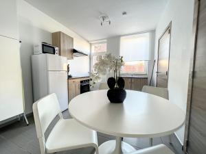 a white kitchen with a white table and chairs at Albert 20 Brussels-charleroi-airport in Charleroi