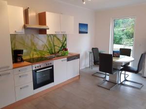 eine Küche mit Herd und Tisch mit Stühlen in der Unterkunft Ferienwohnung Inselglück in Ahlbeck