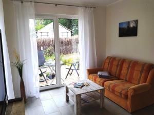 ein Wohnzimmer mit einer Couch und einer Glasschiebetür in der Unterkunft Ferienwohnung Inselglück in Ahlbeck