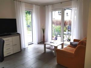 ein Wohnzimmer mit einem TV, einem Sofa und einem Tisch in der Unterkunft Ferienwohnung Inselglück in Ahlbeck + 6 Fotos