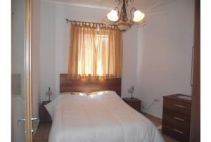 1 dormitorio con cama blanca y ventana en May Flower: Modern Flat close to Airport/Bus Stops en Tarxien