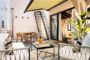 a patio with chairs and tables and a dining room at La Sillería de Arfe in Seville