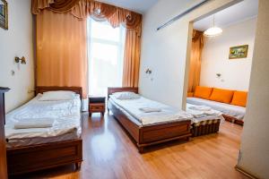 een kamer met 2 bedden en een bank bij Willa Flora in Krynica Zdrój