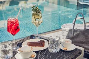 a table with a piece of cake and a drink at Huber's Boutique Hotel in Mayrhofen