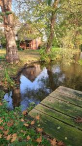a pond in a park with a wooden bridge at Gut Hanerau, Erlenufer keine Monteure in Hanerau-Hademarschen