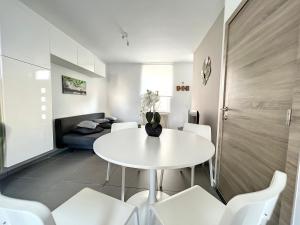 un comedor blanco con una mesa blanca y sillas blancas en Robert 20 Brussels-charleroi-airport, en Charleroi