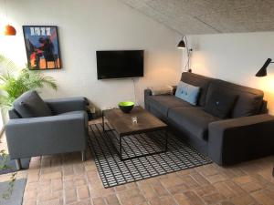 uma sala de estar com dois sofás e uma televisão em Kathrines Bed & Breakfast em Svendborg