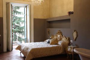 a bedroom with a bed with a chandelier and a sink at Albergo Del Centro Storico in Salerno