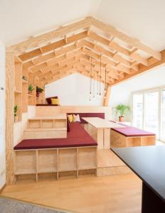 a room with wooden ceilings and a kitchen with wooden counters at Montagu Hostel in Innsbruck