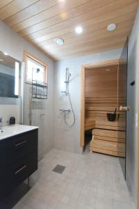 baño con ducha y puerta de madera en LOIMU, en Äkäslompolo