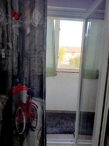 una bicicleta roja estacionada en una habitación con ventana en ModernStudio, en Bragadiru