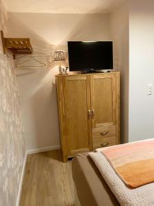 a bedroom with a tv on top of a wooden cabinet at Christianes Apartment - Ebstorf in Ebstorf