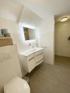 a white bathroom with a sink and a toilet at Christianes Apartment - Ebstorf in Ebstorf