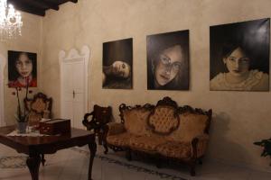 una sala de estar con retratos de mujeres en la pared en Albergo Del Centro Storico, en Salerno