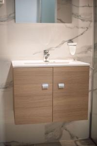 un mobile bagno con lavabo e specchio di My Oneiro Apartments a Ioannina