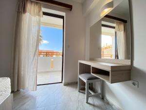 baño con escritorio y ventana grande en Domenica Apartments, en Rethymno