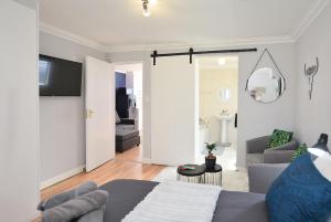 a living room with a gray couch and a living room at Flatlet 2.1km from Iconic Blaauwberg Beach in Cape Town