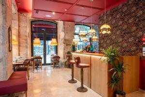 a restaurant with a bar and tables and chairs at Boemio FLH Hotels in Lisbon