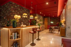 a restaurant with a bar with a table and chairs at Boemio FLH Hotels in Lisbon
