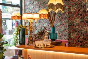 a table with two lamps and glasses on it at Boemio FLH Hotels in Lisbon