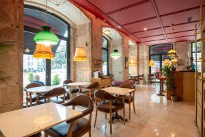 a restaurant with tables and chairs and windows at Boemio FLH Hotels in Lisbon