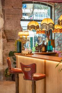 a restaurant with a bar with a chair and lights at Boemio FLH Hotels in Lisbon