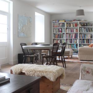 a living room with a table and chairs and bookcases at Hen Ffermdy in Jordanston