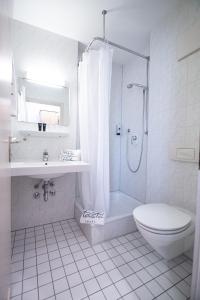 y baño blanco con aseo y ducha. en Taste Smart Hotel Backnang, en Backnang