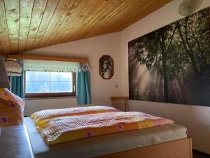 a bedroom with a bed and a large painting on the wall at Ellmauhof in Pfarrwerfen