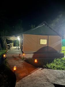 a large tent with lights in front of it at night at Dharti - The Glamping Haven by StayApart in Bijanbāri Bāzār