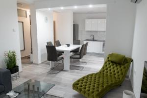 a living room with a table and a green couch at Apartman Škrinjar in Slavonski Brod