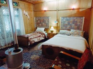 a small bedroom with two beds and a window at Houseboat New Jeddah in Srinagar