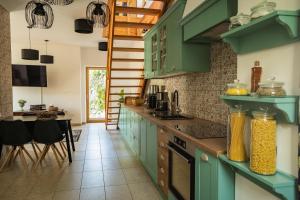 a kitchen with green cabinets and a dining room at Bled House Of Green in Bled