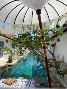 um guarda-chuva sentado ao lado de uma piscina em Kubuwatu Boutique Accommodation em Gili Trawangan