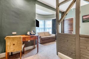 a room with a desk and a chair and a couch at Inn on the Lake by Innkeeper's Collection in Godalming