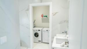 a white bathroom with a washing machine and a washer and dryer at Morar Ourense in Ourense