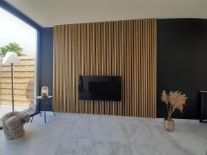 GeluweにあるPuhr Houseの壁に薄型テレビが取り付けられたリビングルーム