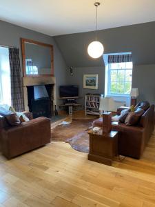 a living room with two couches and a fireplace at Glengorm Castle in Tobermory