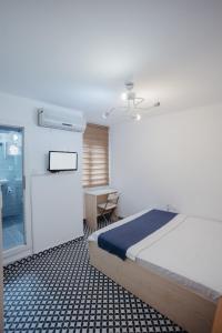 a bedroom with a bed and a desk and a window at Deniz Pansiyon in İzmir