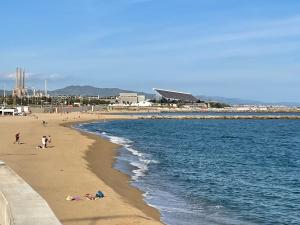 um grupo de pessoas numa praia perto da água em Standing Apartment Barcelona Forum em Barcelona