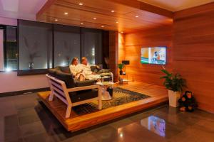 two people sitting in a living room watching a tv at Wellness Dome Penthouse in Kerkrade