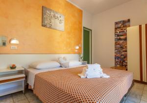 a bedroom with a bed with towels on it at Hotel City in Misano Adriatico