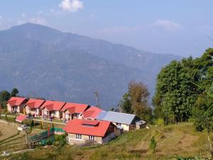 a row of houses with red roofs on a hill at Chibbo Retreat - A Hamlet near Kalimpong by StayApart in Kalimpong
