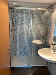 una ducha con una puerta de cristal junto a un lavabo en Standing Apartment Barcelona Forum en Barcelona