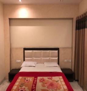 a bedroom with a large bed with a red blanket at Hotel Raj Palace, Amritsar in Amritsar