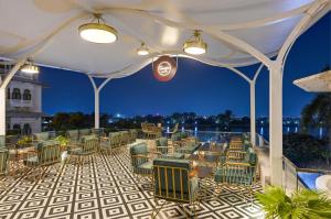 乌代浦Swaroop Vilas - Lake Facing Boutique Hotel的庭院里摆放着许多桌椅
