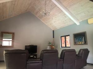 a living room with a couch and a tv at Super villa familiale in Pointe aux Piments
