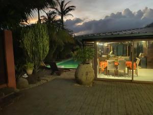 a patio with a table and chairs and a pool at Super villa familiale in Pointe aux Piments