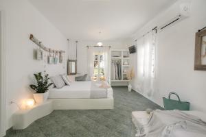 biały pokój z 2 łóżkami i lustrem w obiekcie "Palatiana Agriturismo-Philoxenia Cottages", Private Nature Retreats w Galini